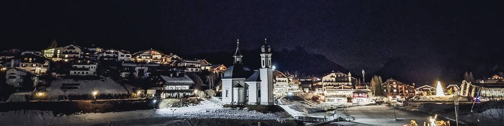 Ein Mann und eine Frau sitzen am Pokertisch und spielen eine Runde Poker. Der Mann hat eine Hand mit Karten, während die Frau konzentriert auf ihre Karten schaut. Die Atmosphäre ist entspannt und