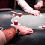 Ein Stapel Pokerchips in verschiedenen Farben und Werten auf einem grünen Pokertisch.