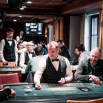 Ein professioneller Pokertisch mit grünem Filz und einem Stapel Pokerchips auf einem Casino-Event.