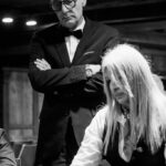 Ein buntes Pokerspiel mit Spielkarten und Pokerchips auf einem grünen Filz-Tisch.