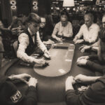 Ein professioneller Pokerspieler mit Sonnenbrille und Kopfhörern konzentriert sich auf sein Blatt während eines Pokerturniers.