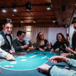 Ein Tisch mit einem Poker-Set, bestehend aus Spielkarten, Pokerchips und einem Dealer-Button.