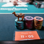Ein Mann und eine Frau spielen Poker am Tisch, während sie Karten halten und Chips stapeln.