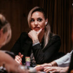 Ein bunt gemischter Stapel von Pokerchips in verschiedenen Farben und Werten liegt auf einem grünen Pokertisch.