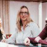 Ein Mann spielt Poker an einem Tisch im Casino, umgeben von anderen Spielern und Chips.