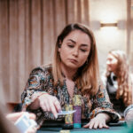 Ein buntes Pokertisch-Setup mit grünen Filzoberflächen, Stapeln von Pokerchips in verschiedenen Farben und einem Kartendeck. In der Mitte des Tisches liegen Karten und Spieler platz
