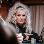 Ein professioneller Pokertisch mit grünem Filz, umgeben von Spielern mit Pokerchips und Karten in der Hand.