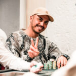 Ein Mann und eine Frau sitzen zusammen an einem Pokertisch und spielen Karten. Der Mann hält seine Karten in der Hand, während die Frau konzentriert auf ihre Karten schaut. Die Atmosphäre ist gespan