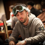 Ein Mann und eine Frau sitzen an einem Pokertisch und spielen eine Partie Texas Hold'em. Der Mann hat gerade seine Karten angesehen und überlegt, während die Frau mit gespanntem Blick auf ihre eigenen Karten wartet