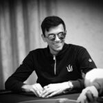 Ein Mann und eine Frau sitzen an einem Pokertisch und spielen Texas Hold'em. Der Mann hat eine Hand aus Spielkarten, während die Frau nachdenklich ihre Karten betrachtet. Das Bild strahlt eine Atmosph