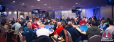 Ein luxuriöses Casino-Panorama mit eleganten Pokertischen, glänzenden Kronleuchtern und stilvoller Einrichtung.