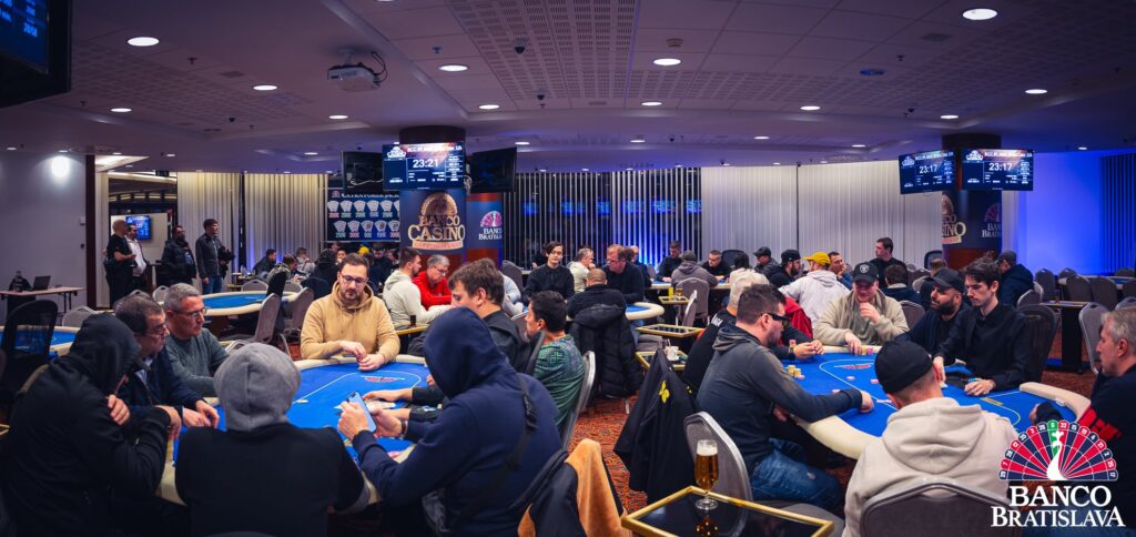 Ein Panoramablick auf eine luxuriöse Pokertischumgebung mit grünen Filzdecken, hochwertigen Spielkarten und Pokerchips in verschiedenen Farben, umgeben von stilvollen Stühlen und