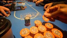 Ein Mann mit Kopfhörern spielt Poker an einem Tisch mit Chips und Karten.