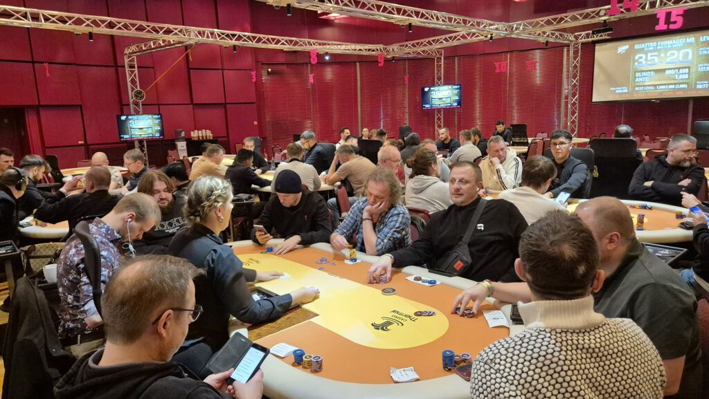 Ein Stapel von Pokerchips in verschiedenen Farben und Werten auf einem grünen Pokertisch.