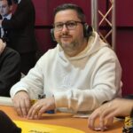 Ein professionell gestalteter Pokertisch mit grüner Filzoberfläche, umgeben von hochwertigen Pokerchips, Karten und einem Dealer-Button.