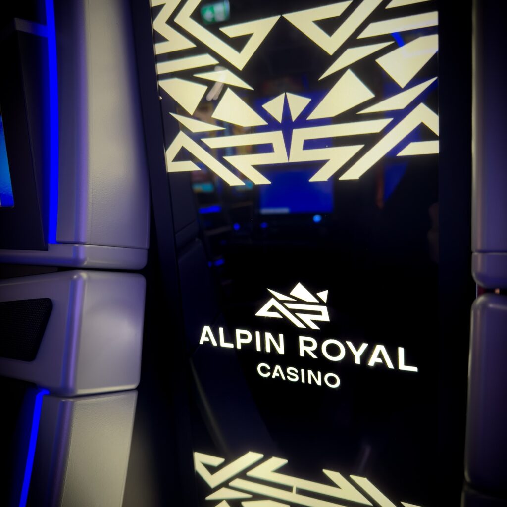 Ein glücklicher Mann sitzt an einem Pokertisch und hält eine Hand voller Pokerchips. Er lächelt und schaut in die Kamera. Im Hintergrund sind weitere Spieler und Karten zu sehen.