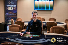 Ein bunter und lebendiger Pokertisch mit Spielkarten, Jetons und Getränken, umgeben von einer Gruppe von Menschen, die konzentriert und gespannt an einem Pokerspiel teilnehmen.
