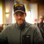 Ein professioneller Pokerspieler konzentriert sich auf sein Kartenspiel während eines Turniers.