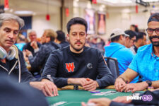 Ein professioneller Pokerspieler, Adrian Mateos, sitzt am Pokertisch während der WSOP 2023 und konzentriert sich auf sein Spiel.