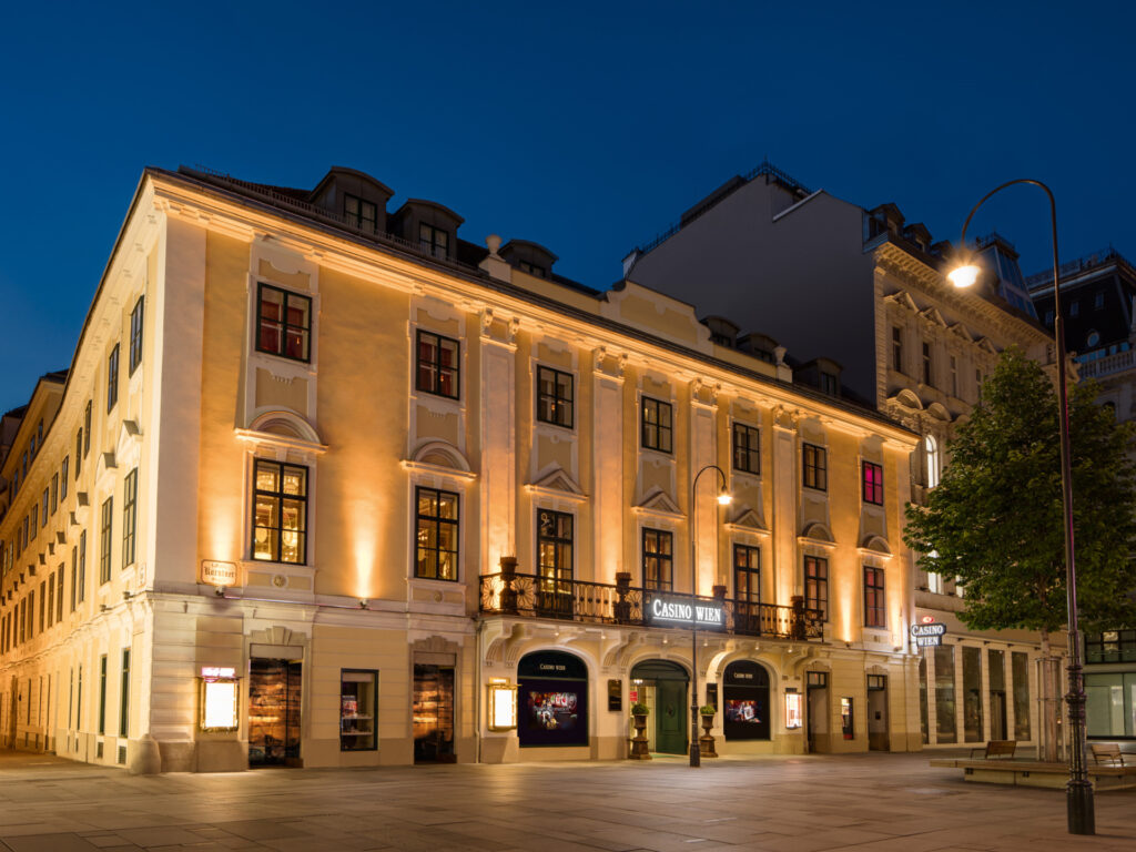 Ein eleganter Spieltisch im Casino Wien, umgeben von Stühlen und Glücksspielchips, mit einer stilvollen Beleuchtung und einem klassischen Dekor im Hintergrund.