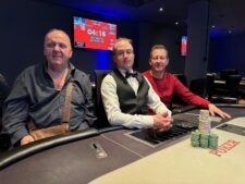 Ein glücklicher Pokerspieler mit einem breiten Lächeln hält stolz seine Gewinnchips in die Luft.