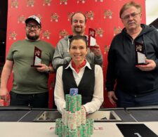 Ein professioneller Pokerspieler mit Sonnenbrille und Kappe sitzt an einem Pokertisch und hält seine Karten in der Hand. Im Hintergrund sind andere Spieler und Chips zu sehen.