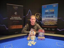 Ein professioneller Pokertisch mit grüner Filzoberfläche, umgeben von Stühlen und beleuchtet von einer Deckenleuchte. In der Mitte des Tisches liegt ein Stapel Pokerchips und Spiel