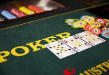 Ein Pokertisch mit Spielkarten und Chips, auf dem der Flop offenliegt und ein großer Pot in der Mitte steht.