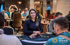 Ein professionelles Pokerspiel mit einem Spieler, der Karten hält und konzentriert auf den Tisch schaut, umgeben von anderen Spielern und Pokerchips.