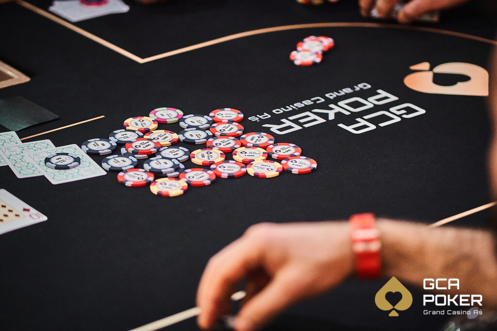 Ein stilvolles Pokertisch-Setup mit grünem Filz, umgeben von leuchtenden Karten und Pokerchips.