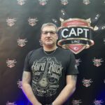 Ein professioneller Pokertisch mit grünem Filz und Pokerchips in verschiedenen Farben, die auf dem Tisch verteilt sind. In der Mitte des Tisches sind Spielkarten und Gläser mit Getränken