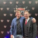 Ein Kartenspiel mit Pokerchips und Spielkarten auf einem grünen Pokertisch.