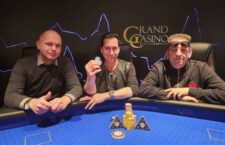 Ein Pokertisch mit grüner Filzoberfläche, umgeben von Spielkarten, Pokerchips und Getränken. Mehrere Personen sitzen um den Tisch und spielen Poker.