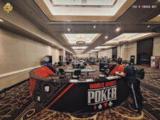 Ein Foto von einem Pokertisch im Horseshoe Casino in Las Vegas während der World Series of Poker. Spieler sitzen um den Tisch herum, Karten und Chips liegen verteilt. Im Hintergrund sind weitere Spieler und