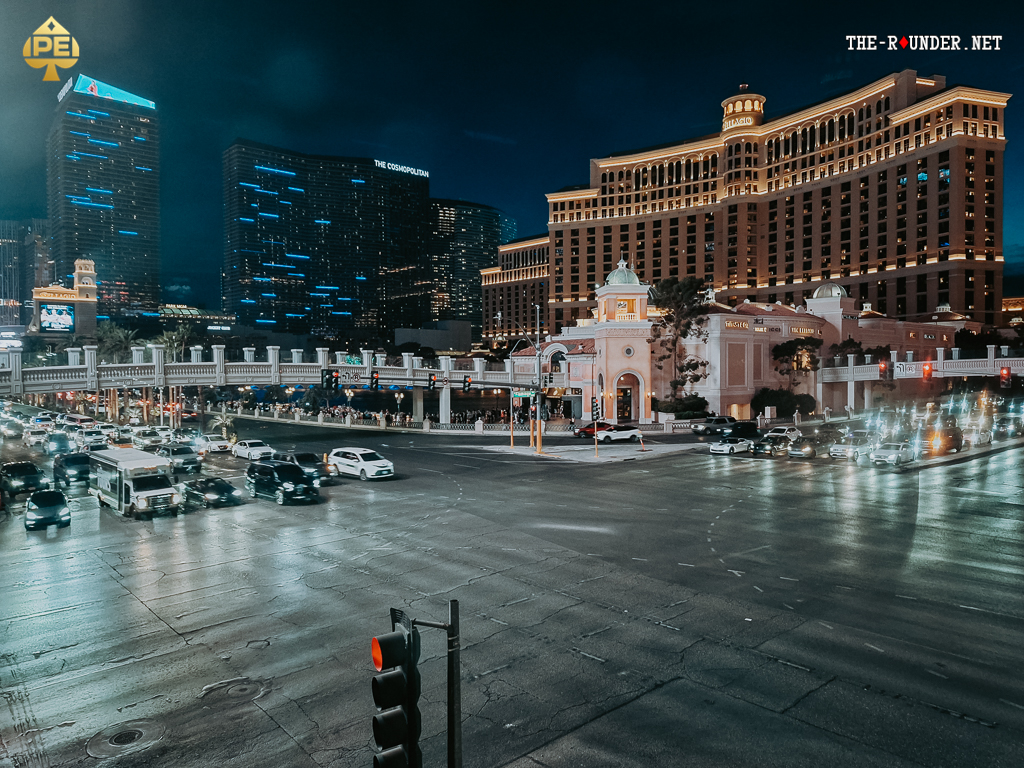 Ein belebter Blick auf den Las Vegas Strip mit den Hotels Bellagio und The Cosmopolitan im Vordergrund, umgeben von lebhaften Lichtern und Menschenmassen.