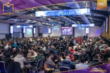 Ein bunter Haufen von Pokerchips in verschiedenen Farben und Werten, die auf einem grünen Pokertisch gestapelt sind. Einige Karten und Spielmarken sind ebenfalls zu sehen.