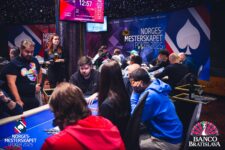 Ein Haufen roter und schwarzer Pokerchips, die auf einem grünen Pokertisch liegen.