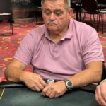 Ein professioneller Pokerspieler konzentriert sich auf seine Hand während eines Turniers.