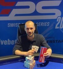 Ein Mann und eine Frau sitzen an einem Pokertisch und spielen Texas Hold'em. Der Mann hat einen Stapel Pokerchips vor sich, während die Frau gerade ihre Karten betrachtet. In der Mitte des Tisches liegen