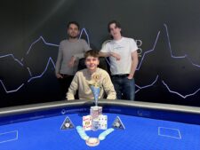 Ein Mann und eine Frau sitzen an einem Pokertisch, konzentriert auf ihre Karten und Chips. Die Frau trägt eine schwarze Bluse und der Mann ein blaues Hemd. Im Hintergrund sind Pokerchips