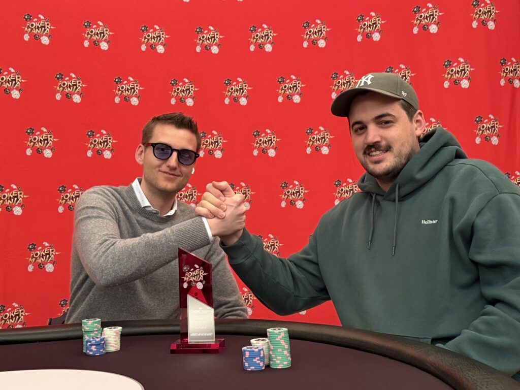 Ein professioneller Pokertisch mit grünem Filz, umgeben von vier Spielern, die Karten halten und Pokerchips stapeln. Ein Dealer in der Mitte des Tisches mischt Karten. Die Spieler haben konzent