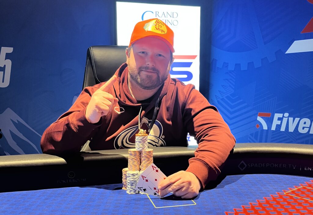Ein Mann und eine Frau sitzen an einem Pokertisch und spielen Karten. Der Mann hält seine Karten in der Hand und schaut konzentriert auf den Tisch, während die Frau mit gespanntem Blick ihre K