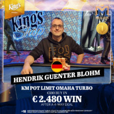 Ein Spieler hält zwei Karten in der Hand und betrachtet konzentriert den Flop auf dem Pokertisch während andere Spieler im Hintergrund ihre Karten prüfen.