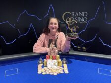 Ein Mann sitzt an einem Pokertisch und betrachtet konzentriert seine Karten. Im Hintergrund sind Pokerchips und eine Glühlampe zu sehen.