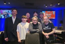 Ein professioneller Pokertisch mit grünem Filz, Chips und Spielkarten, umgeben von vier Spielern, die konzentriert ihre Karten betrachten.