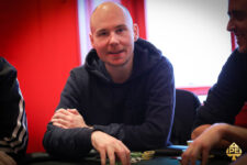 Ein junger Mann namens Tobias Schwecht sitzt an einem Pokertisch und konzentriert sich intensiv auf sein Kartenspiel.