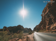 Ein majestätisches rotes Felsformation im Valley of Fire State Park, umgeben von goldenen Sonnenstrahlen.