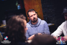 Ein Pokertisch mit Spielkarten, Chips und Spielern, die an einem Turnier teilnehmen.