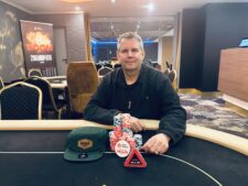 Ein Pokerturnier mit dem Titel "OESOP PLO Turbo Bounty", mit Spielkarten und Pokerchips auf dem Tisch, während Spieler in Aktion sind.