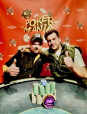 Ein Pokertisch mit Spielkarten, Pokerchips und Spielerhänden in Aktion während eines Pokerturniers.